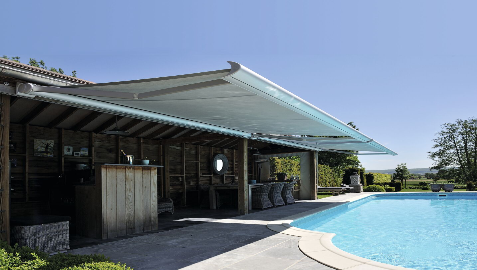 Die Brustor B50 Kassettenmarkise bietet Sonnenschutz an einer Terasse mit angrenzendem Pool