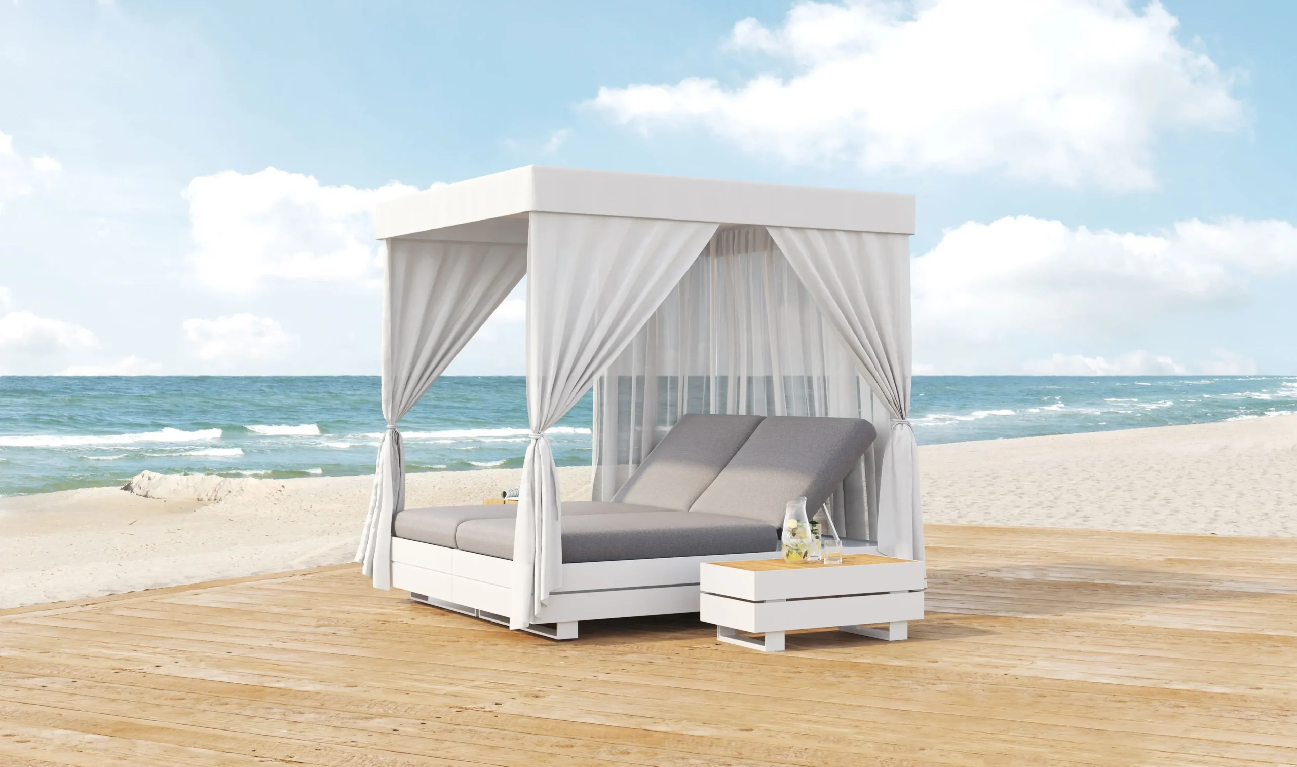 Zu den Terrassenmöbeln von Solpuri gehören auch Liegen, wie dieses BOXX Daybed, welches auf einer Holzfläche am Strand steht.