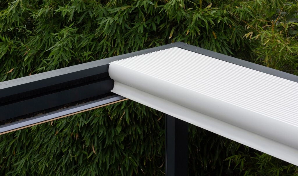 Das Lamellenpaket eines geöffneten Lamellendaches mit weißen Lamellen in einem schwarzen Dach.