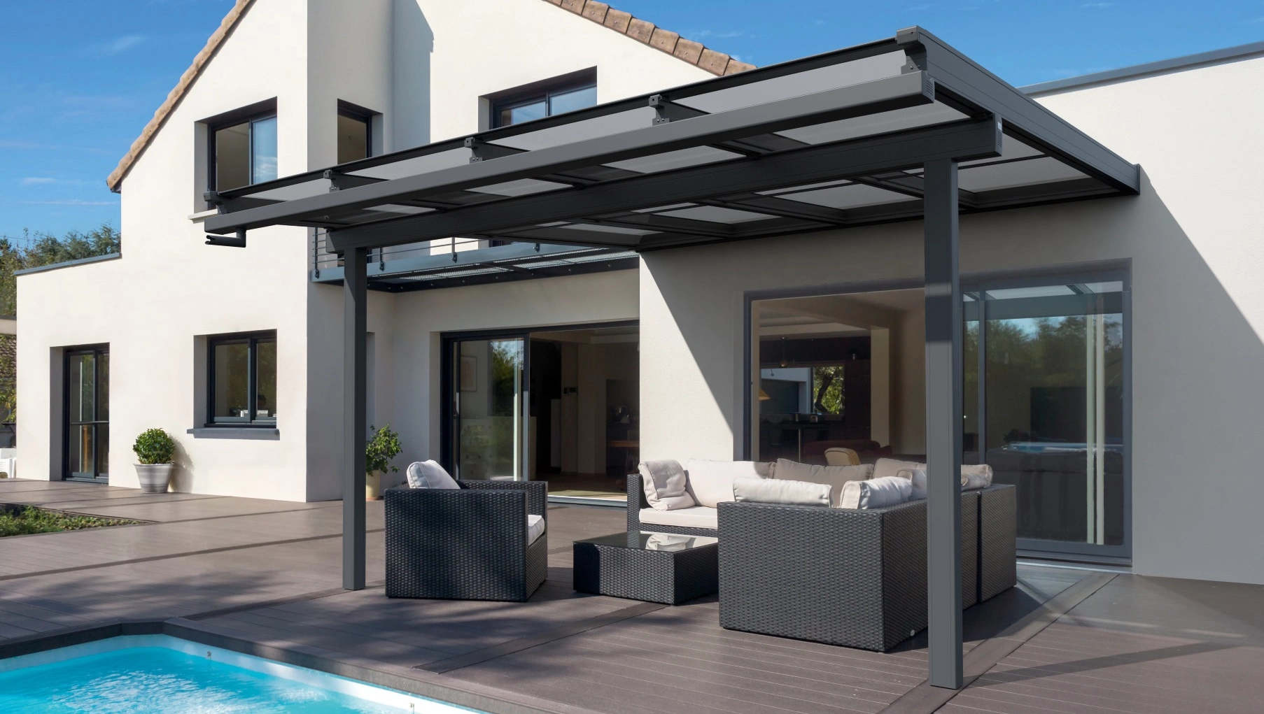 Das Glasdach Lewens Murano Integrale ZIP beschattet mit heruntergelassener ZIP-Markise den Sitzbereich eines Pools.