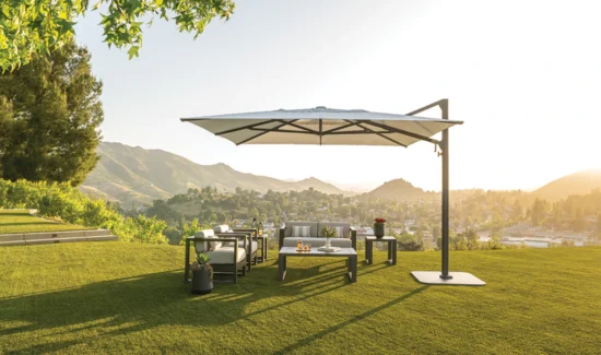 Ein Shademaker Polaris Sonnenschirm in eckiger Form beschattet einen Outdoor-Sitzbereich.
