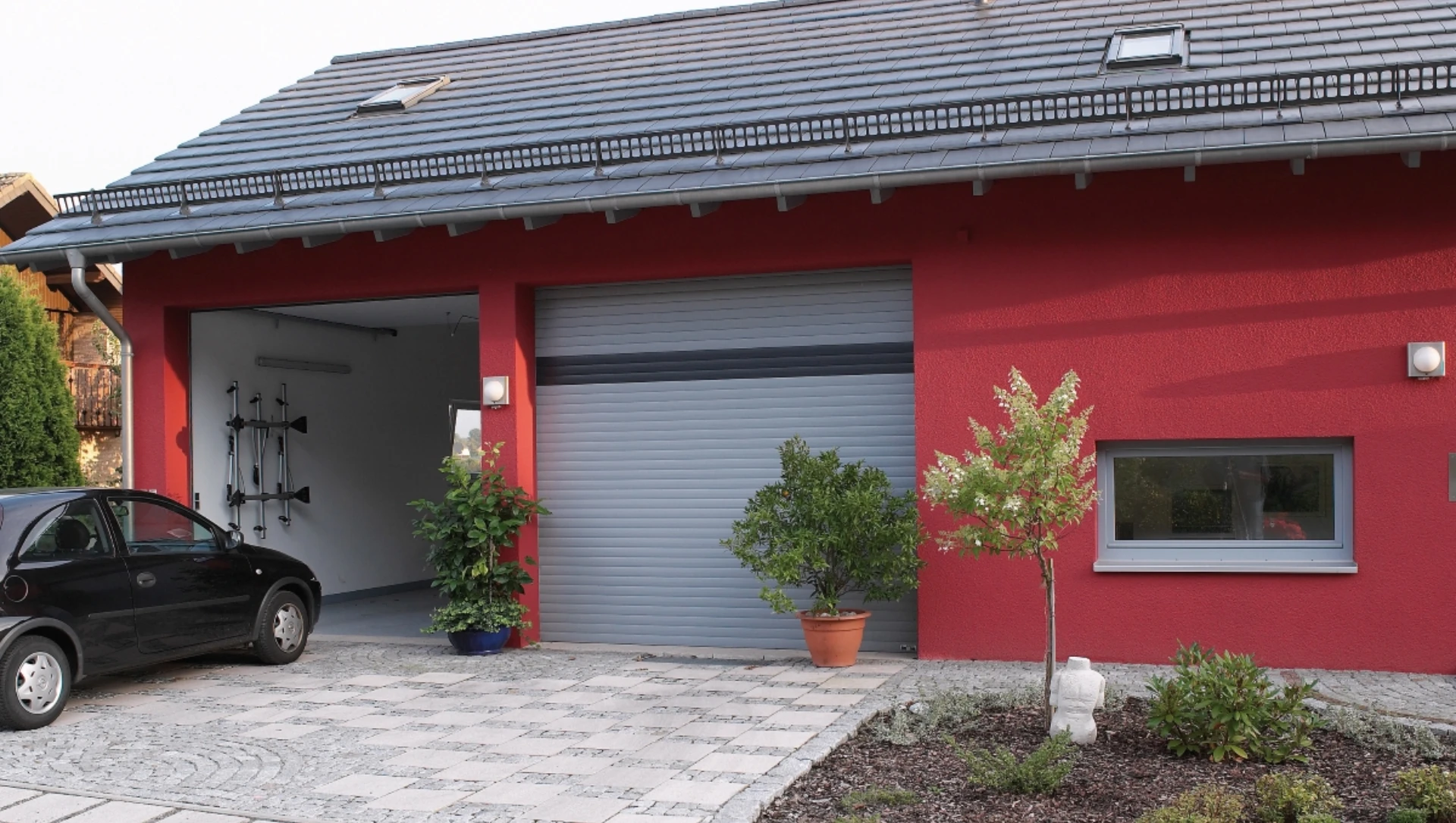Das Garagentor ROMA SILENTO an zwei angrenzenden Garagen, das eine Tor geöffnet, das andere geschlossen.