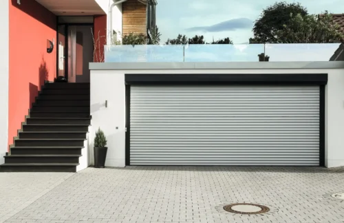 Ein Außen im Torrahmen montiertes ROMA ROLENTO mit silberfarbenen Lamellen und schwarzem Rahmen.