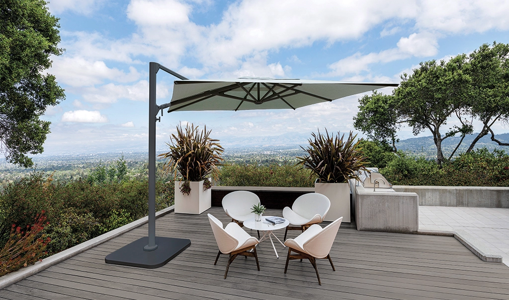 Ein Shademaker Polaris Sonnenschirm auf einer Terrasse über einem kleinen SItzbereich.