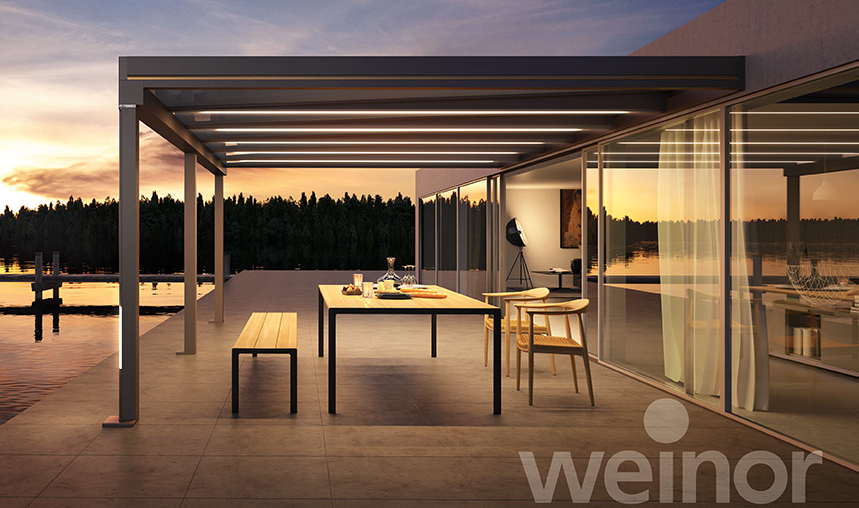 Ein Weinor Terrazza Pure mit LED-Stripes erhellt einen Außensitzbereich.