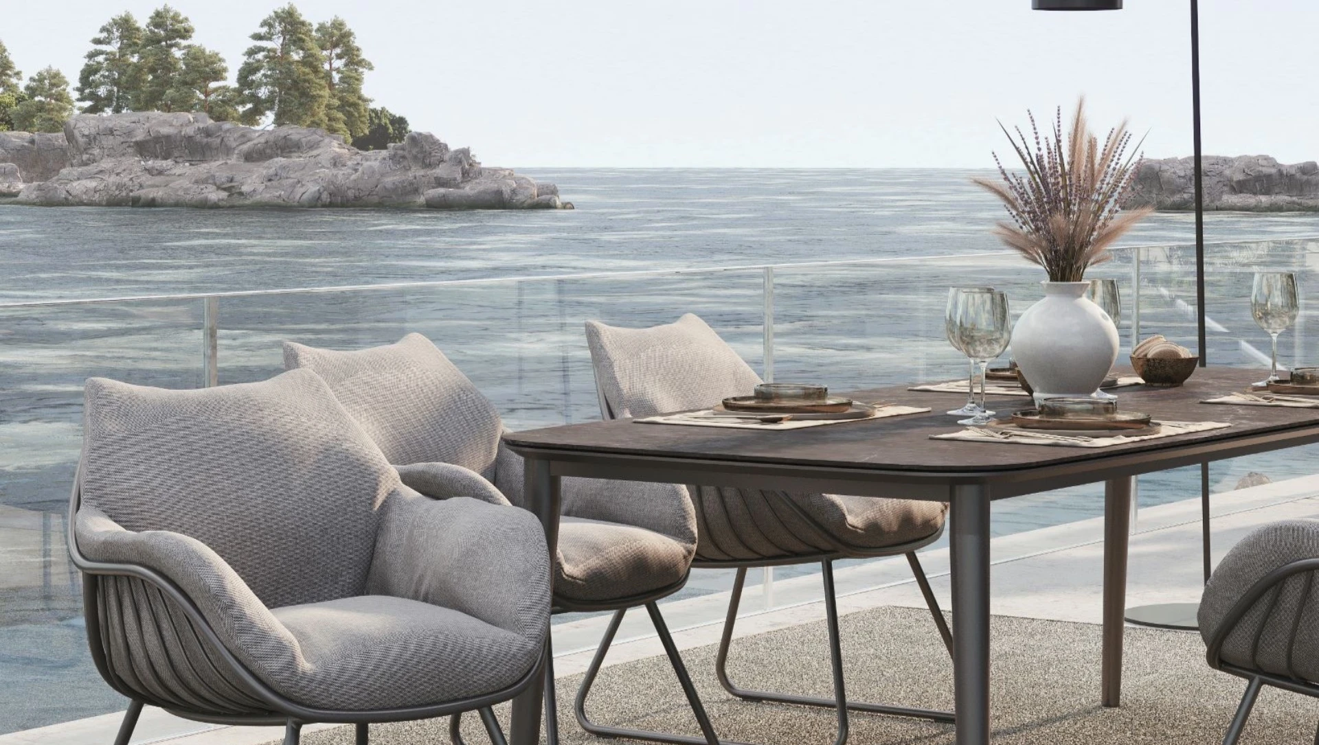 Die Terrassenmöbel CHARLIE Esstisch und CHILL Dining Sessel von Solpuri stehen auf einer Terrasse am Meer.