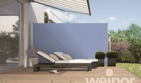 Blaue Seitenmarkise auf Terrasse zum Nachbarhaus hin.