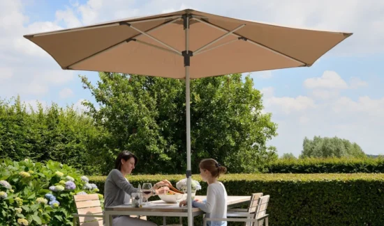 Eine Mutter mit Tochter beim Essen an einem Tisch im Freien unter einem Prostor P2 Sonnenschirm.