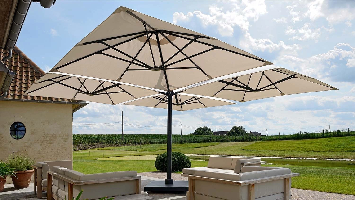 Vier quadratische Sonnenschirme auf dem Multimast des Prostor P6 zur Beschattung mehrerer Outdoor-Sofas.