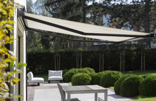 Ausgefahrene Markise mit dunkelgrauen Gelenkarmen und hellem Stoff.