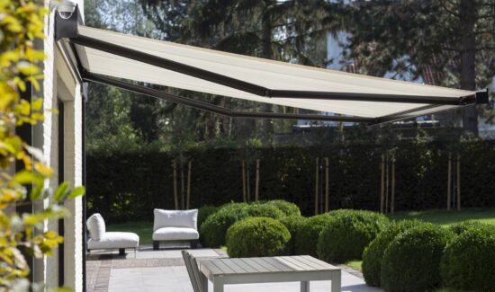 Ausgefahrene Markise mit dunkelgrauen Gelenkarmen und hellem Stoff.