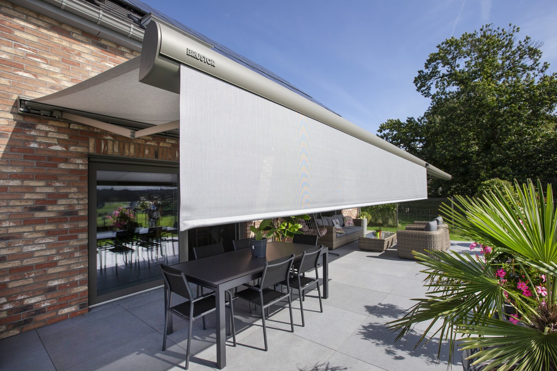 Markise von vorne links mit ausgefahrenem Volant.